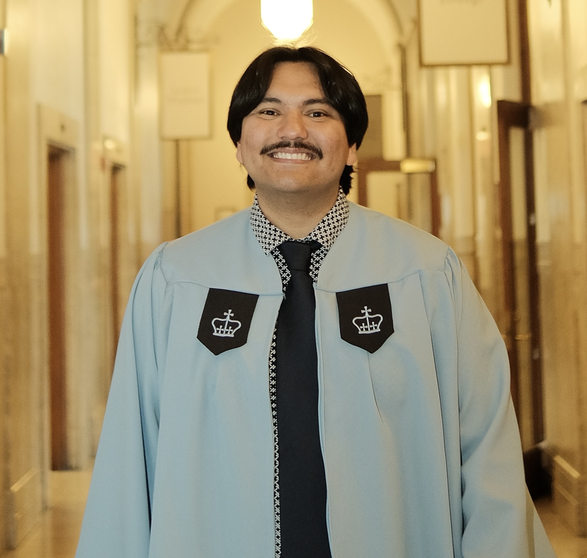 Moises Mata wearing a Columbia graduation gown